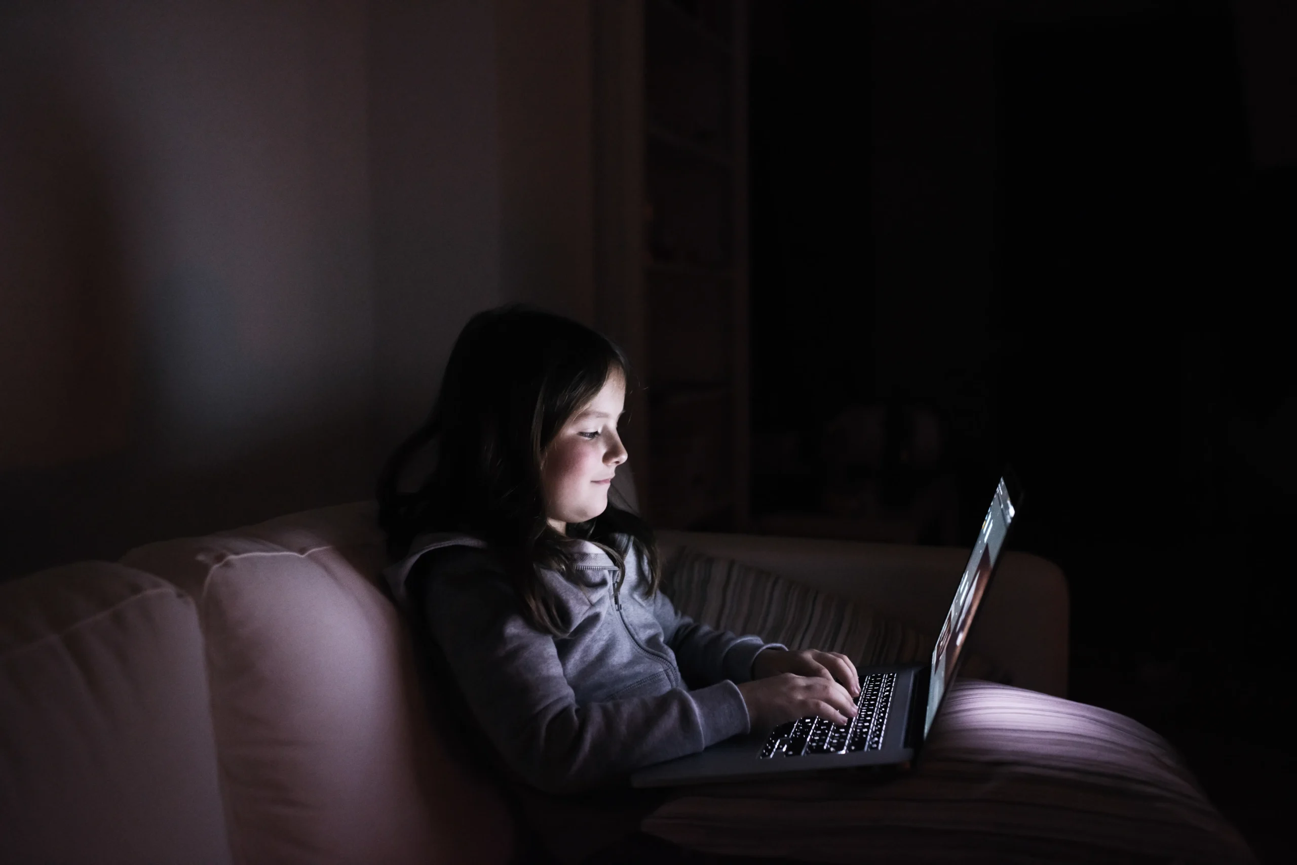 Girl sitting on coach on computer