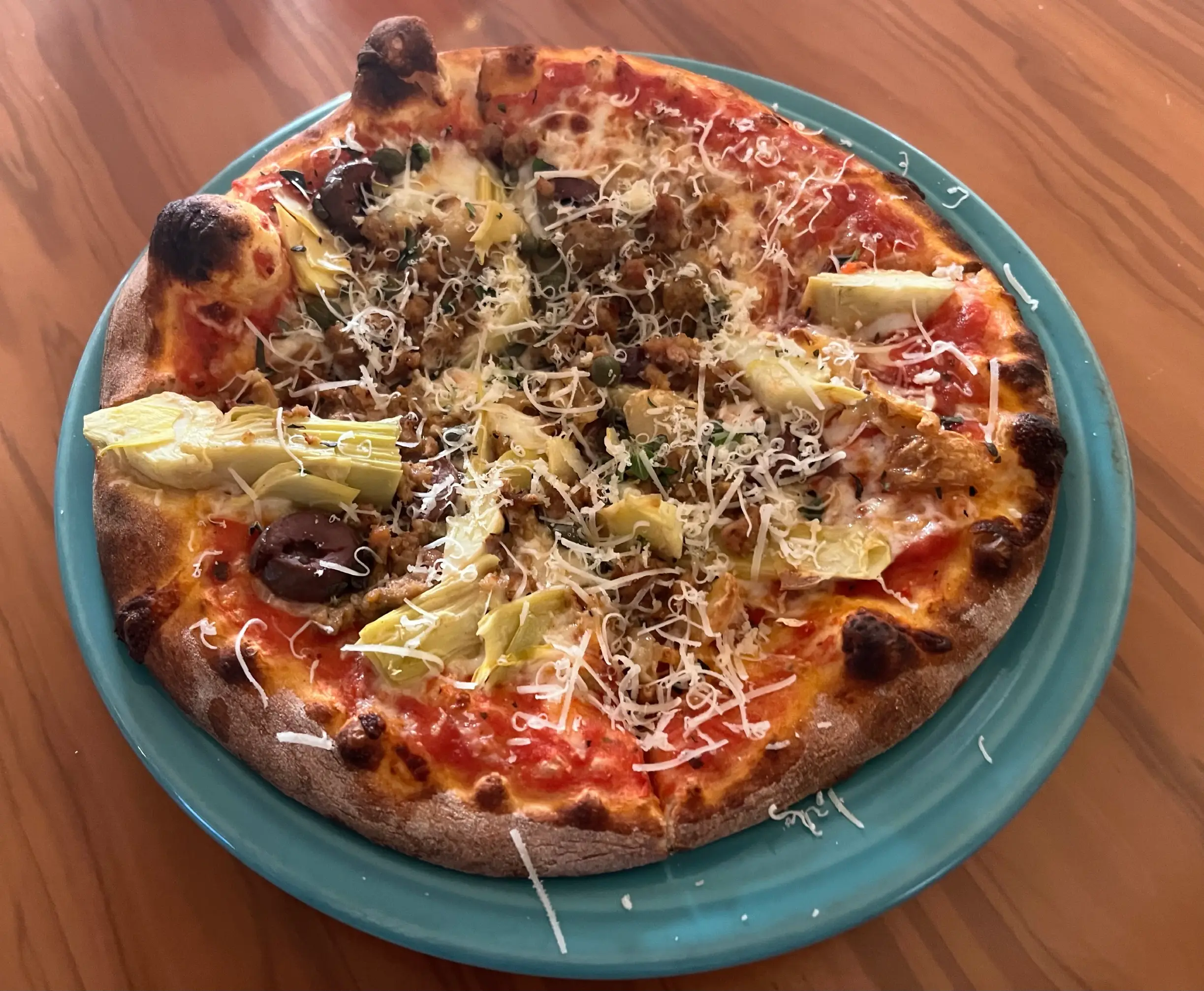 Il Vicino bambino pizza with artichoke hearts, capers, kalamata olilves, and sausage